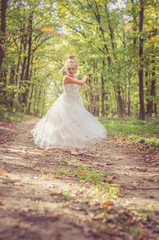adorable child in long white wedding dress