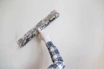 Putty the wall gypsum putty with spatulas.