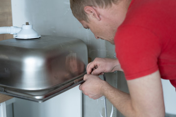 repair and decoration. master sets the sink in the kitchen