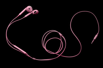 Pink wired headphones earbuds, headset on a black background. Music day.