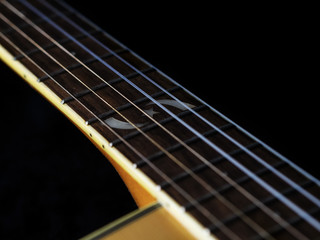 Fototapeta premium six - string acoustic guitar on a black background. low key. music day
