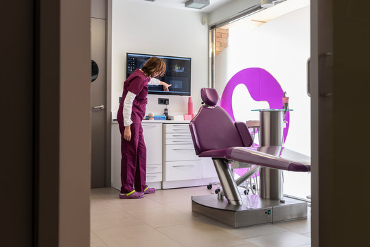 Dentist pointing out a dental anomaly on a screen in dental clinic.