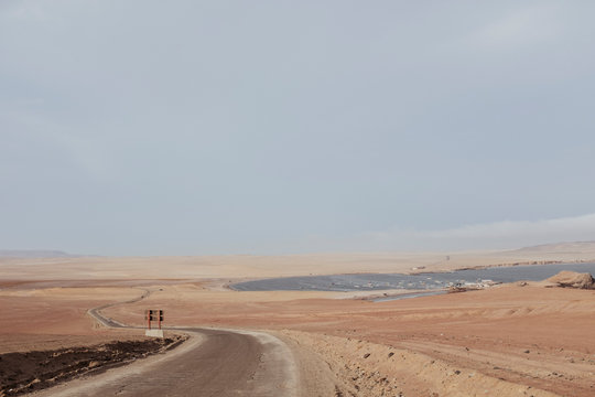 A dirt track and ocean in the background against blue sky,Paracas,Peru