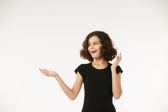 A girl in black clothes on a white background depicts the emotion