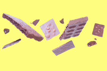 Levitating pieces of broken chocolate on a white background...