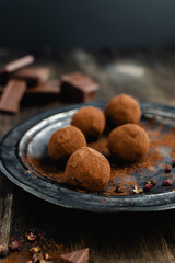 dark chocolate candy truffles with sichuan pepper on dark background