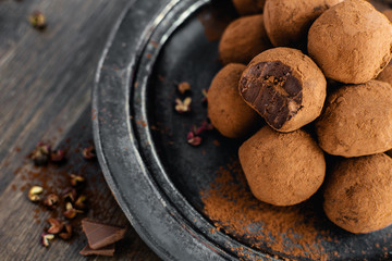 dark chocolate candy truffles with sichuan pepper on dark background