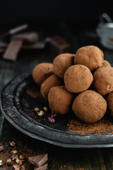 dark chocolate candy truffles with sichuan pepper on dark background