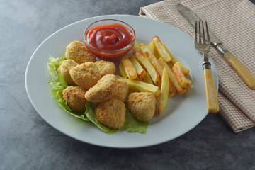 Chicken nuggets with french fried potatoes and ketchup, top view. Fast food.