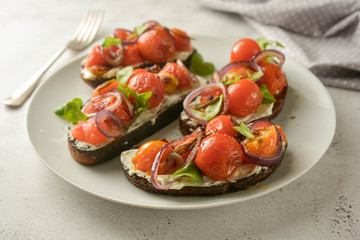 Vegan sandwiches, bruschettas with cheese cream and cherry tomatoes. Whole bread slices.