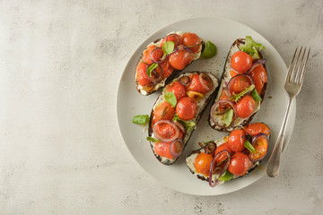 Bruschetta with cherry tomatoes and cheese cream. Healthy, vegan food, snack. Copy space.