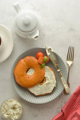 Breakfast with bagels and cheese, cherry, basil, tea cup. Healthy food.