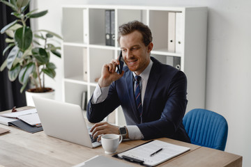 Businessman answering phone call and smiling friendly