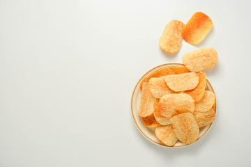 Potato chips in a plate isolated on a white background. Fast food snack.