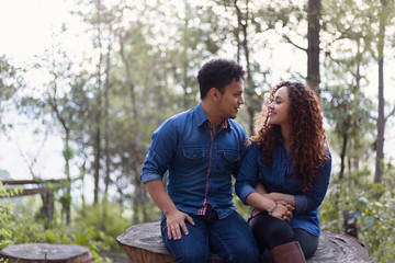 Fototapeta premium boyfriends in love watching each others eyes sitting in the forest at sunrise