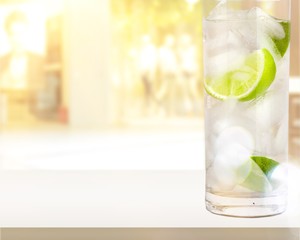Glasses with fresh organic cucumber water on wooden table, on grey background