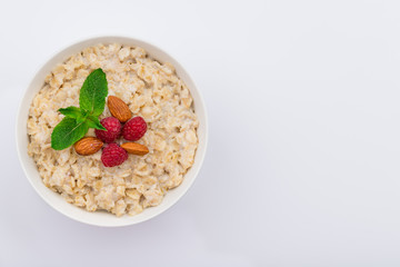 Oatmeal with almonds and raspberries and mint top view copy space