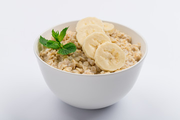 Oatmeal with banana and mint on white, not isolated