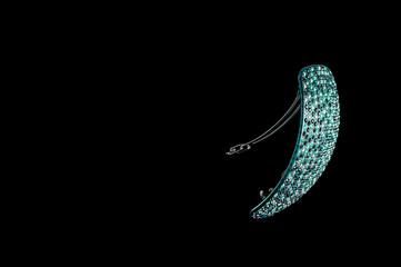 Bright hair clip blue with crystals on a black background, isolate