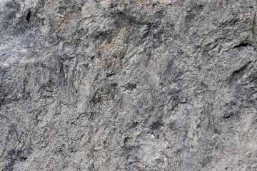 Dark gray stone surface is porous. This is a horizontal cement-concrete background. Texture of stone.