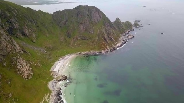Aerial, tilt up, drone view over Bleikstranda beach, towards a mountain and the Norwegian sea, on a moody and foggy, summer day, on Andoya island, in Nordland, Norway