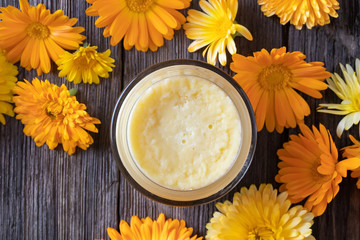 Homemade calendula and shea butter ointment, top view - obrazy, fototapety, plakaty