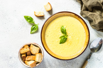 Zucchini Cream soup with basil and croutons on white.