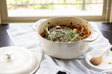 Home-cooked roast with vegetables and fresh herbs in a dutch oven cooking pot