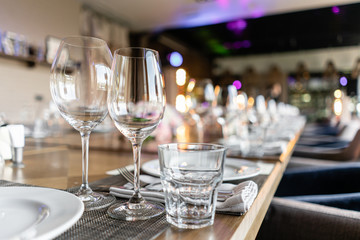 Wine glasses in the foreground. Wedding Banquet or gala dinner. The chairs and table for guests,...