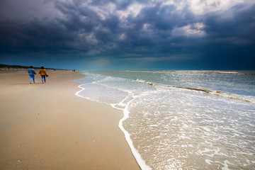 couple walking along the beach in sunshine