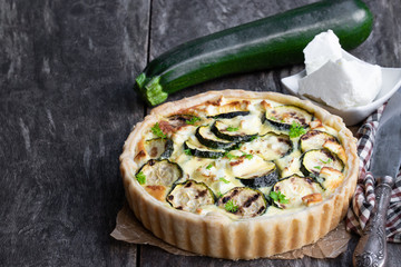 Homemade courgette and feta quiche on rustic wooden table