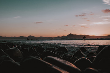 Atardecer con piedras en primer plano en playa de Famra isla de Lanzarote