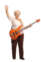 Elderly female guitarist with an electric bass guitar waving at the camera
