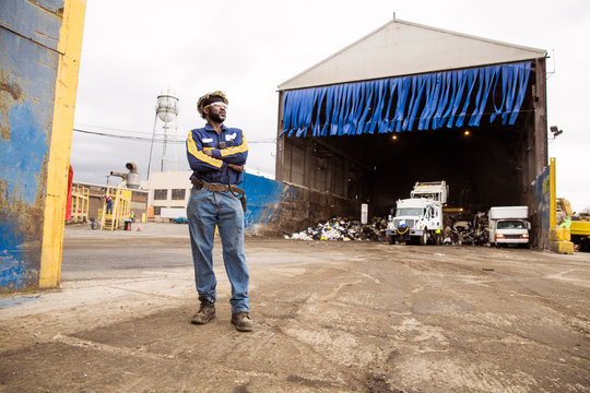 Worker standing next to hangar on recycling plant