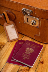 Polish passport and travel suitcase on a wooden table. Accessories for the traveler before the...