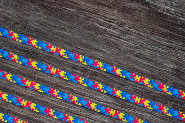 World Autism awareness day with Puzzle ribbon on wooden background