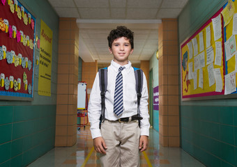 Portrait of school boy (10-11) standing with backpack in school corridor © Cavan for Adobe