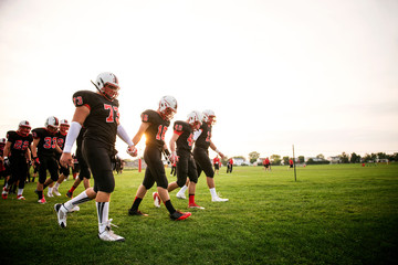 Naklejka premium Football players (16-17) walking on playing field