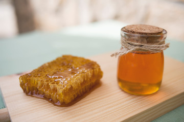 honey in a jar and honeycomb on the table