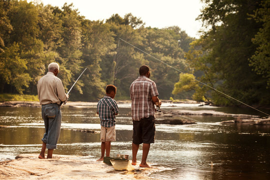 Multigenerational family fishing in river