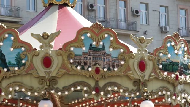 Illuminated merry go round in park. Brightly illuminated roundabout spinning in wonderful amusement park at daytime