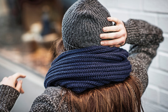 Young woman putting on knit hat
