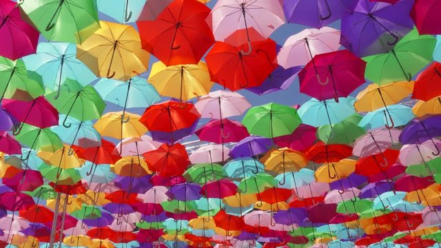 Top view of street decorated with multicolored umbrellas in Aix en Provence, France. Beautiful colorful parasols hanging in air above at sunny summer day