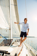 Fototapeta premium Man leaning off sails of private yacht
