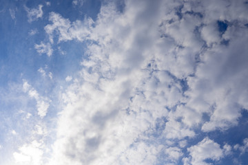 Fototapeta premium Blue sky in the soft white clouds. Natural cloudscape background, texture. Wide Horizontal Wallpaper With Copy Space