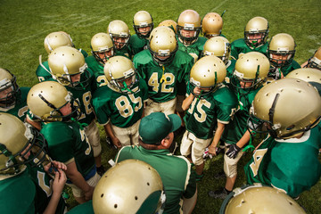 American football team talking with coach in field © Cavan for Adobe