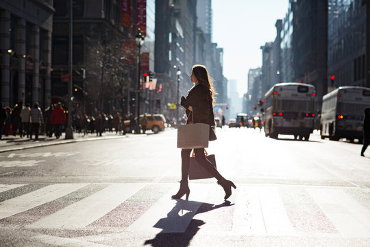 Side view of woman walking on pedestrian crossing