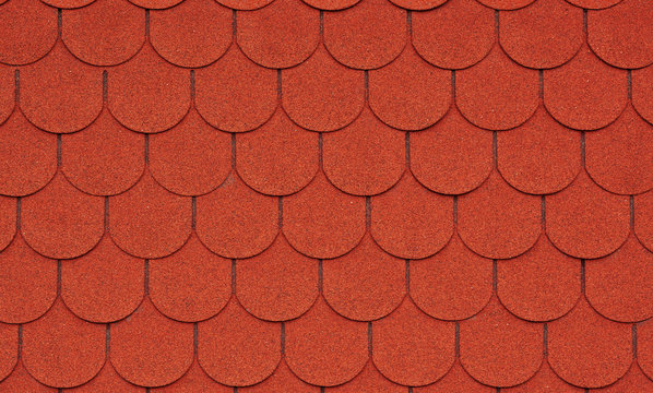 Close up view on red asphalt roofing shingles background.