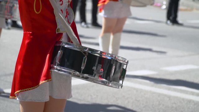 Close-up of female hands drummers are knocking in the drum of their sticks. Street performance on the occasion of the holiday