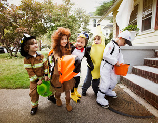 Obraz premium Smiling children in costumes during Halloween